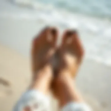 Stylish feet with black nail polish on a beach